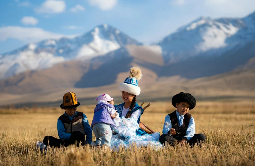 Kyrgyz woman and children in traditional dress in a mountain pasture